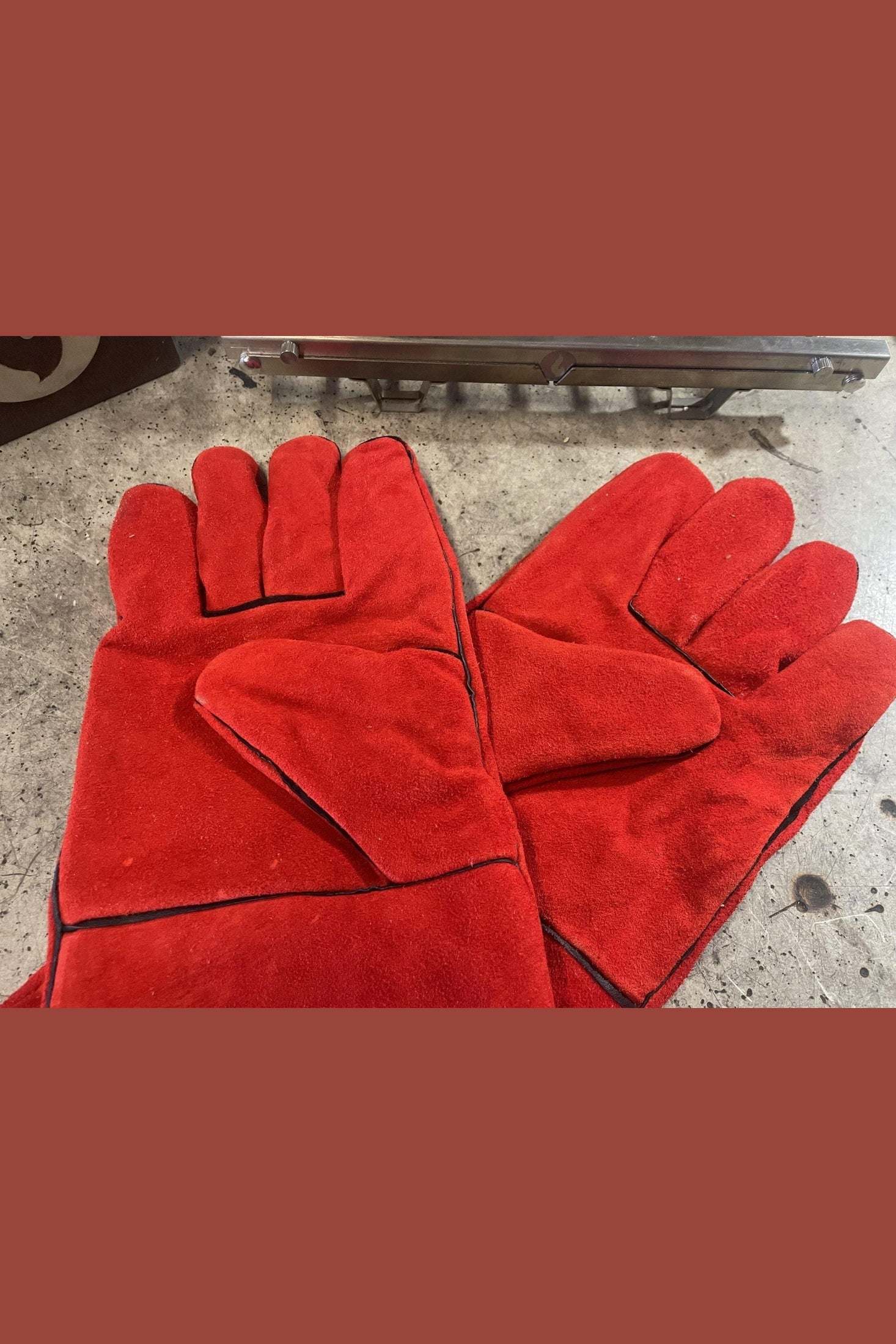 Red fireproof gloves for welding and cooking, crafted from durable leather with bold design.