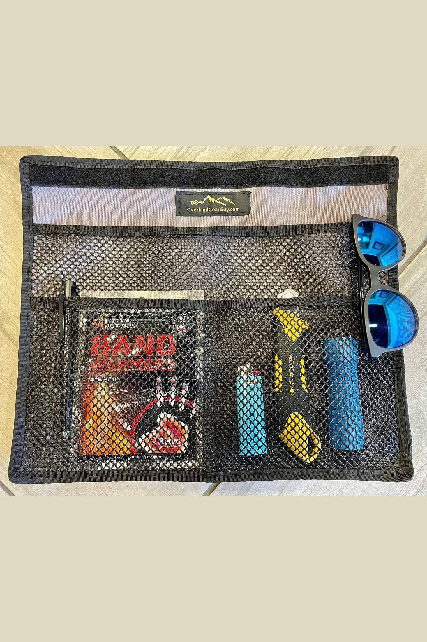 Four Wheel Camper mesh-pocketed organizer pouch with sunglasses, flashlight, phone accessories, and compact design for easy attachment