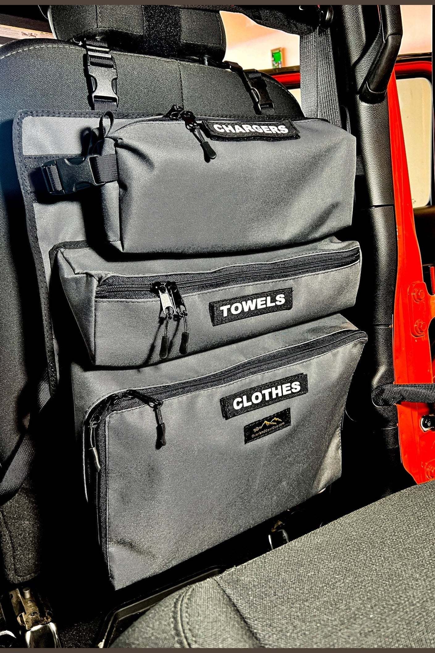 Arches Overlander 1 Seat Organizer with labeled cargo pockets for chargers, towels, and clothes in vehicle seat back