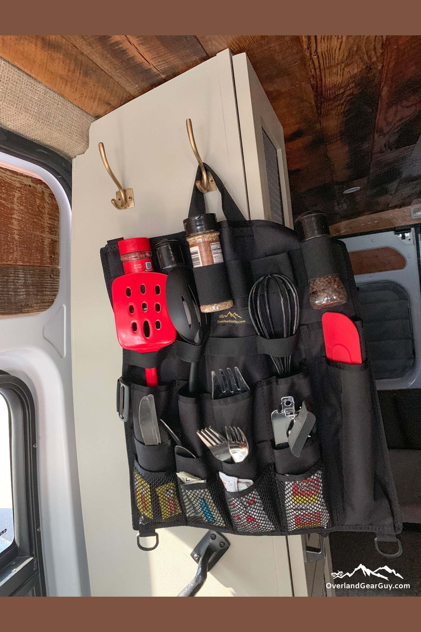 Back Country Utensil Organizer hanging on van door with utensils and spices stored in pockets and elastic loops