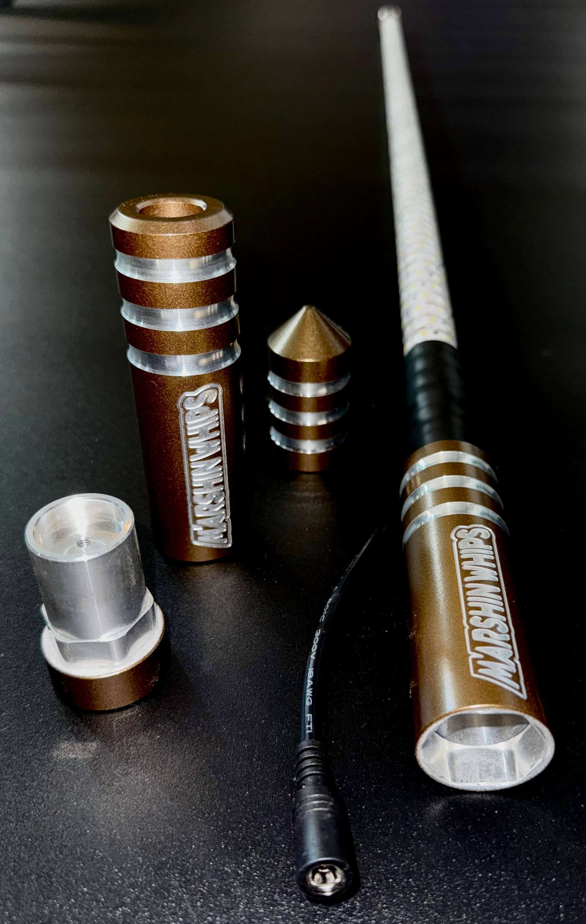Game Changer Whips Bronze Edition 5/8" Rod with durable metal components and cable connection on black surface