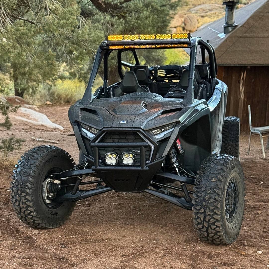 Polaris RZR Pro R off-road vehicle with 36-inch LED light bar and rugged tires in desert setting