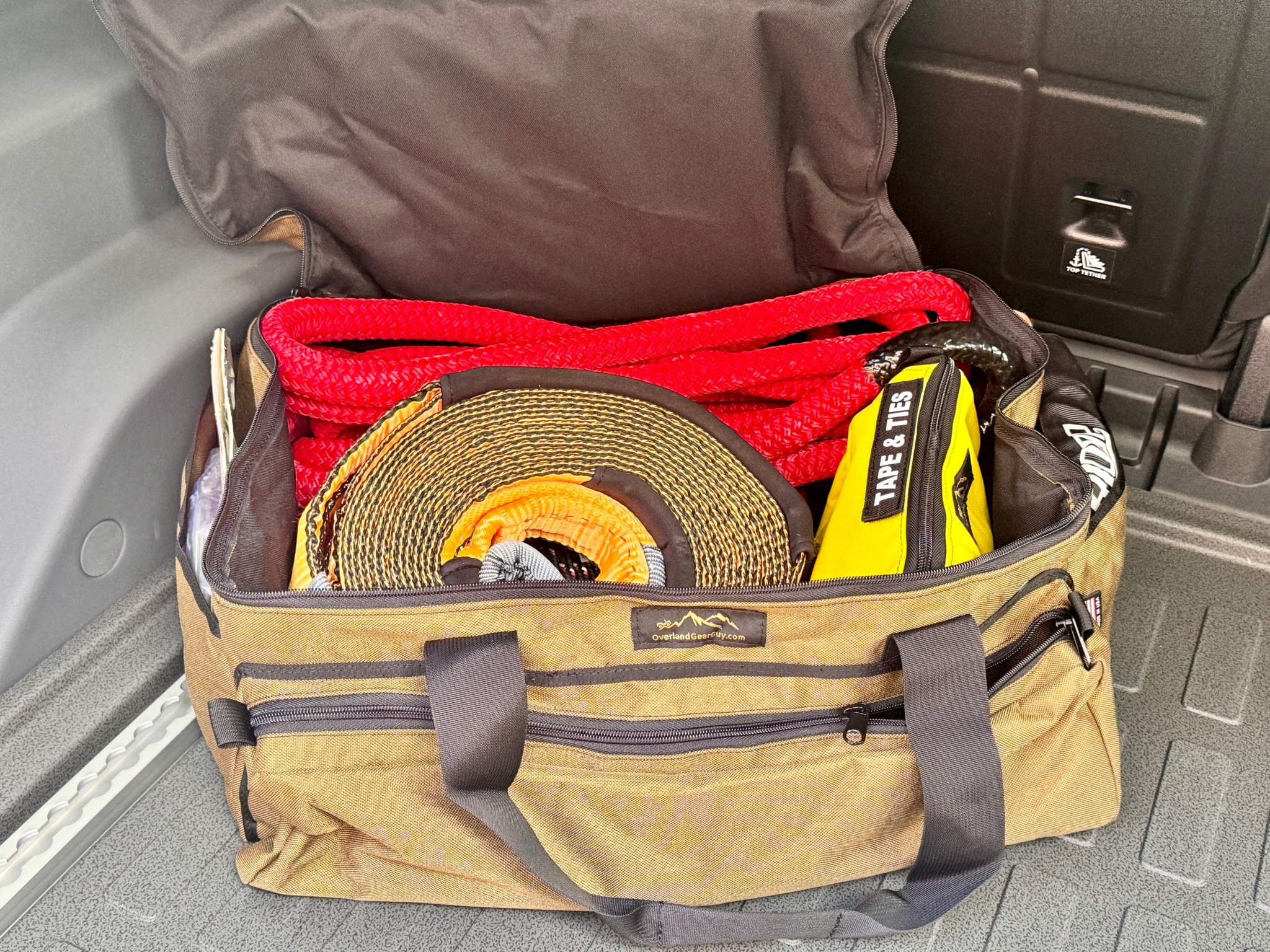 Deluxe Recovery Gear Bag open in vehicle trunk with organized recovery straps and tools inside