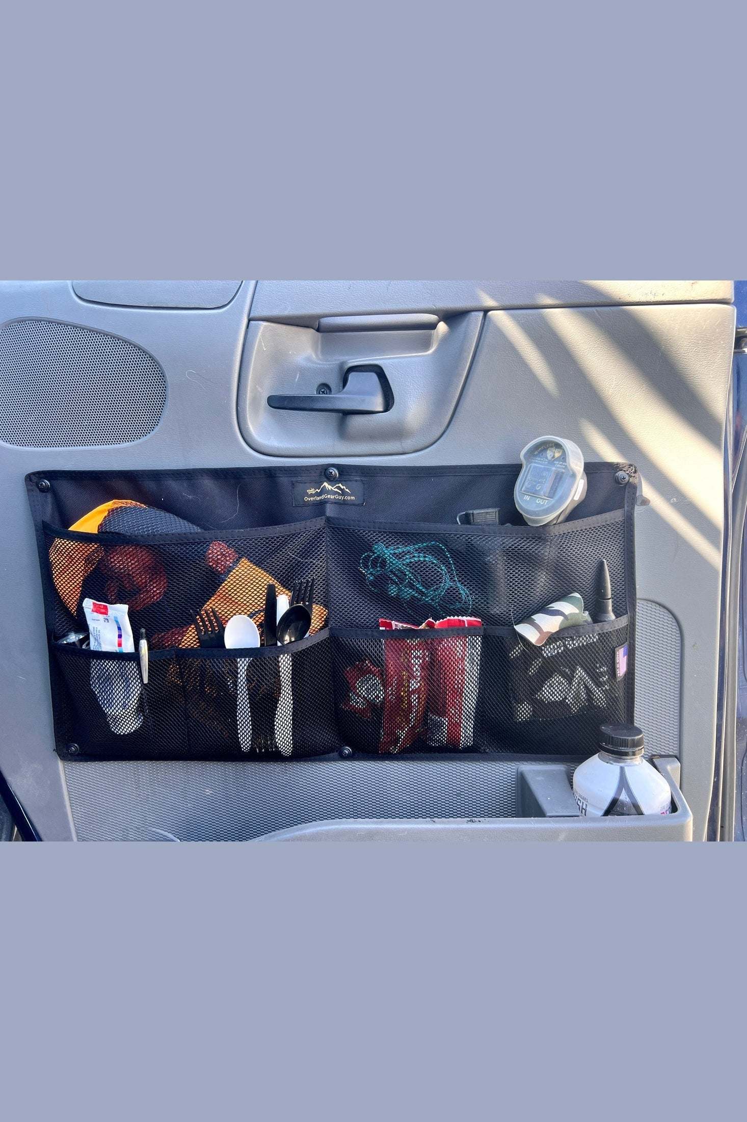 Econoline door organizer installed on vehicle door with mesh storage pockets holding various items