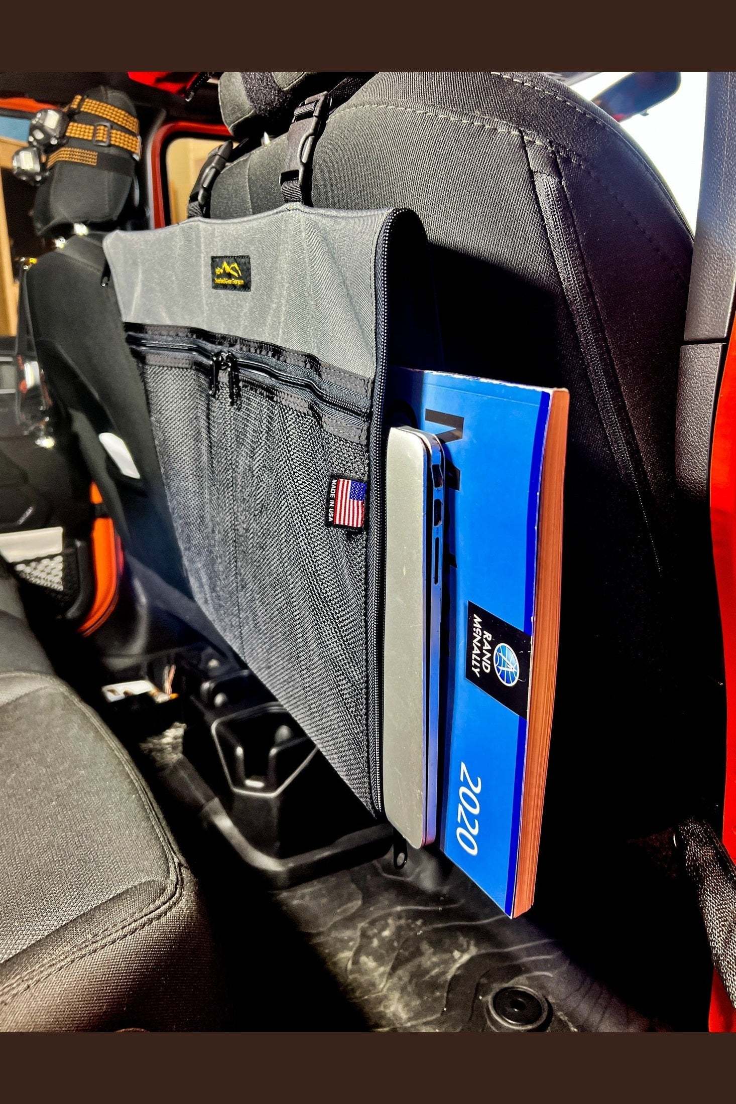 Road Atlas Pouch attached to car seatback holding maps and laptop
