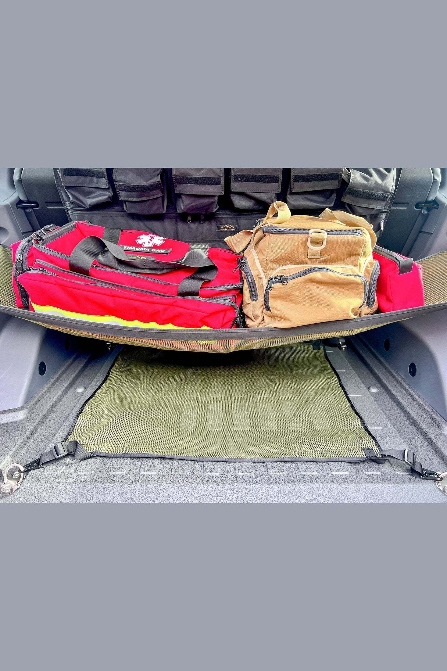 INEOS Grenadier Cargo Nets in vehicle trunk securing luggage for organized storage.