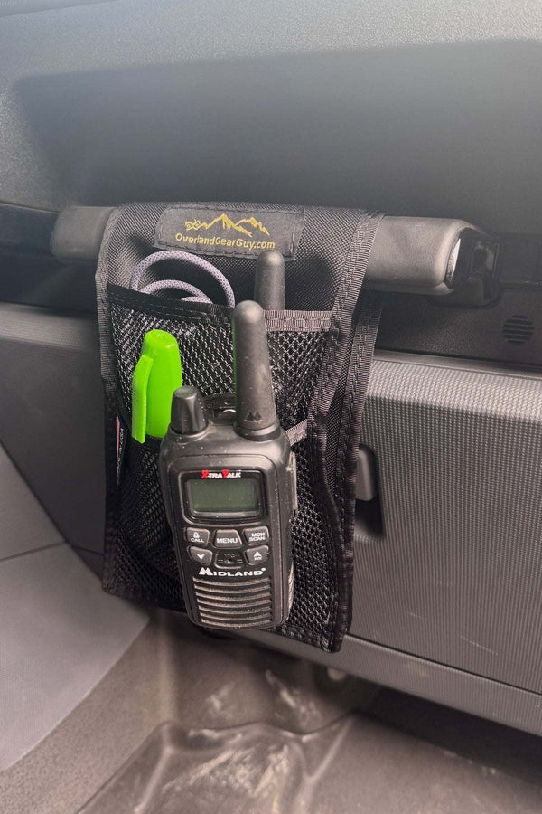 Grenadier Grab Handle Mesh Flat Pocket attached to vehicle grab handle with organized small items including walkie-talkie and pens