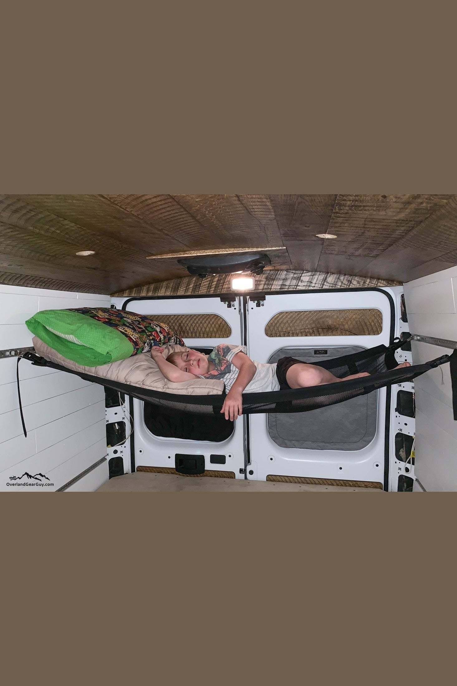 Campervan hammock with adjustable straps inside campervan, providing comfortable and space-saving sleeping or storage solution