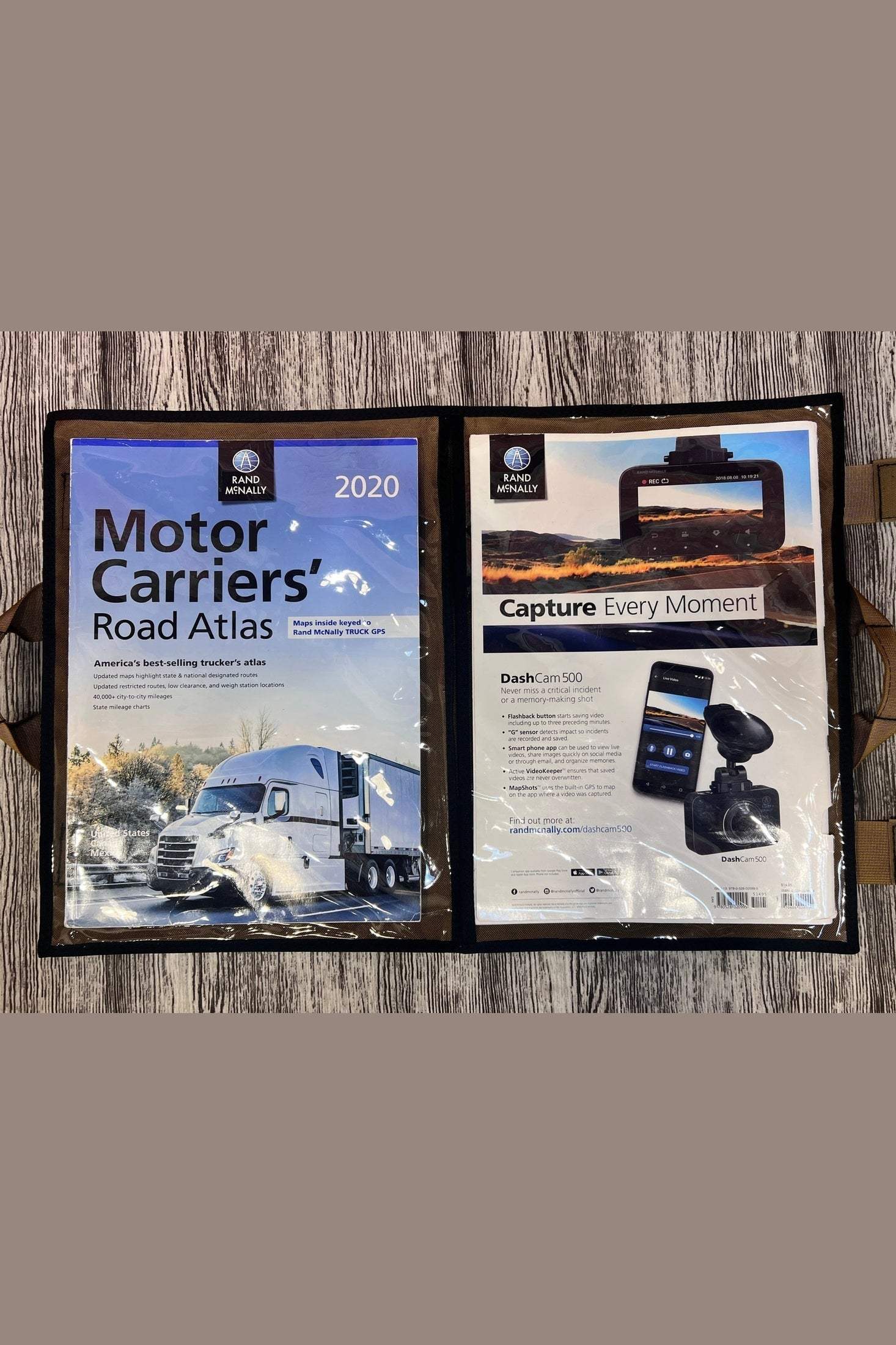 CLEAR Road Atlas Map Pouch holding Motor Carriers' Road Atlas and device advertisement on wooden surface