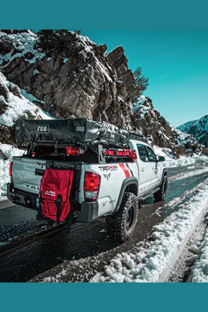 Overland Tailgate Trash/Storage Bag on a truck driving through snowy mountains.
