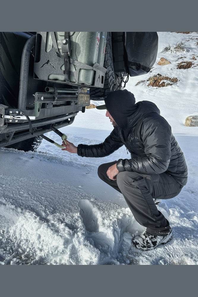 Person using Hitch Hero Soft Shackle in snowy terrain.