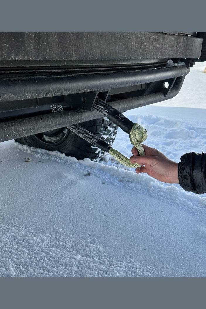 Soft shackle attached to a vehicle hitch in snowy conditions.