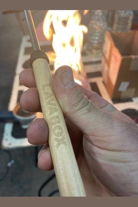 Nyx Styxx roasting skewer with branded wooden handle, perfect for campfire cooking.