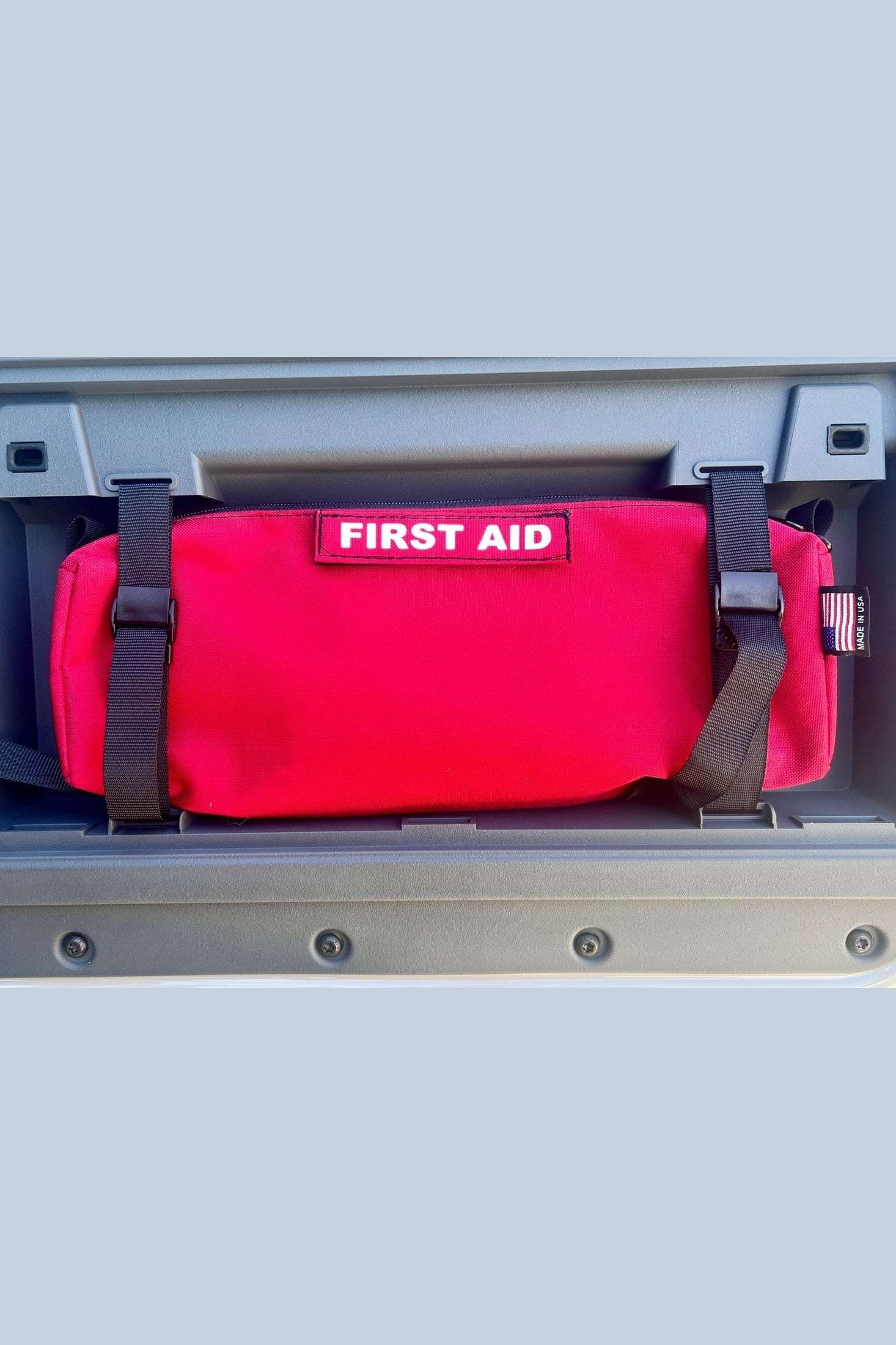 INEOS Grenadier Rear Door Storage Bag in red with "First Aid" label attached inside vehicle door compartment