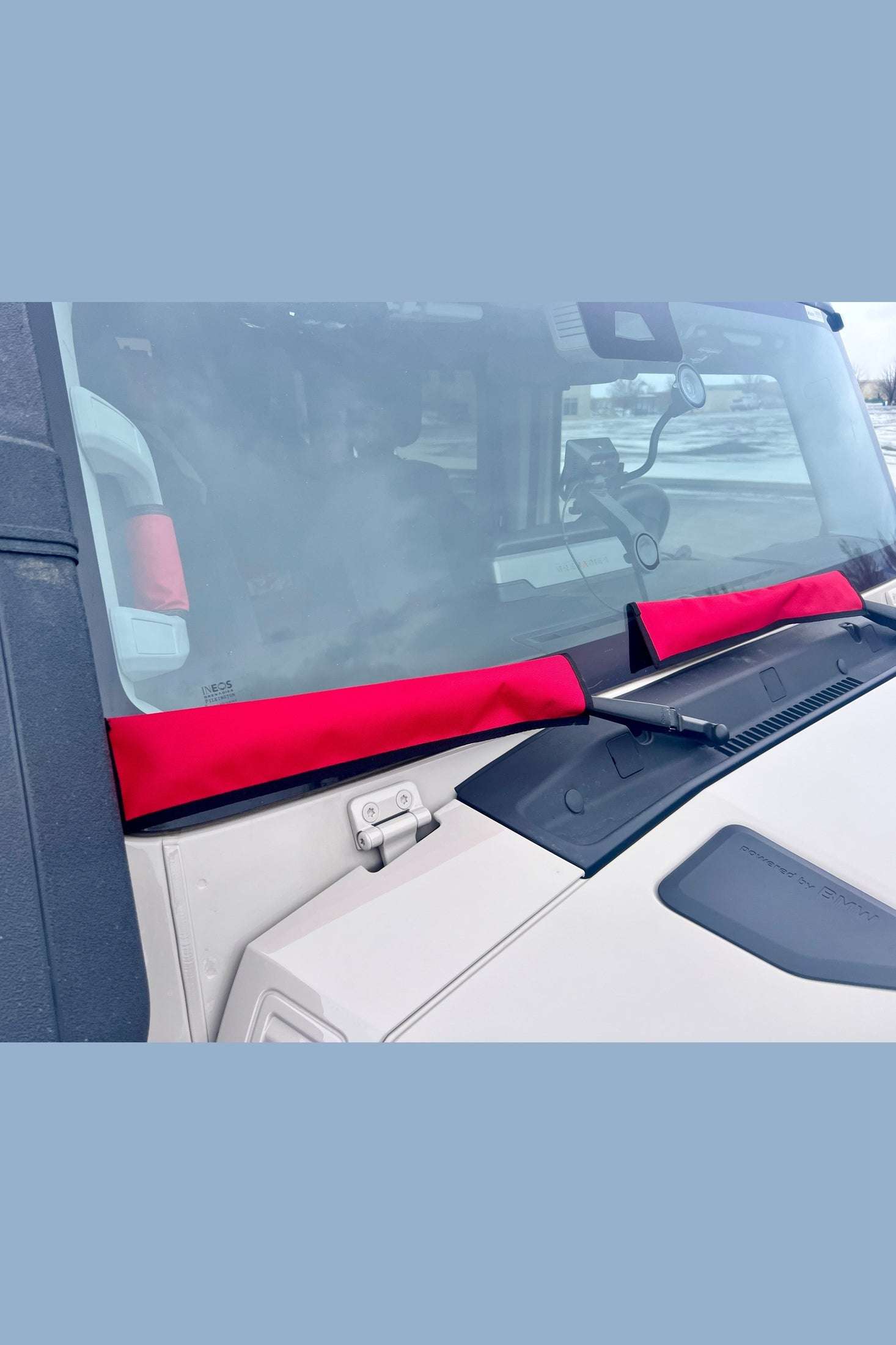 Red INEOS Grenadier Wiper Sleeves installed on vehicle windshield wipers for winter protection