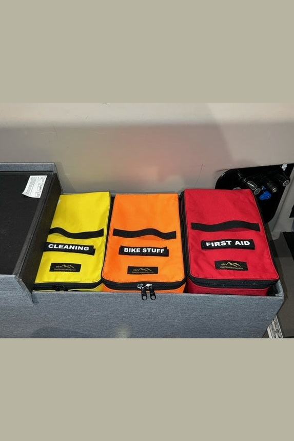 JB Large Storage Bags in yellow, orange, and red for organized storage with labeled sections for cleaning, bike stuff, and first aid.