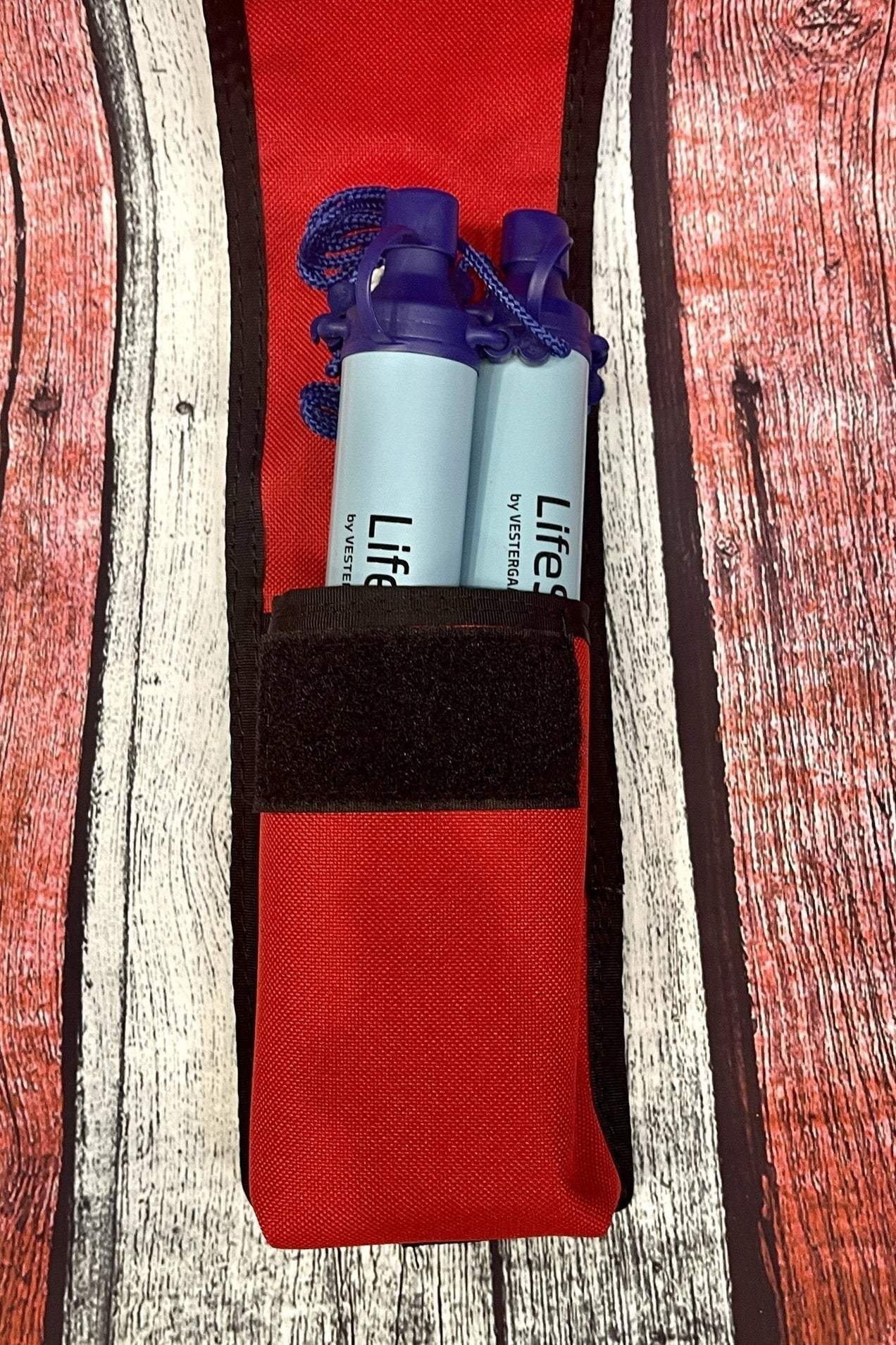 Compact red LifeStraw Pouch holding two LifeStraw water filters with secure attachment options