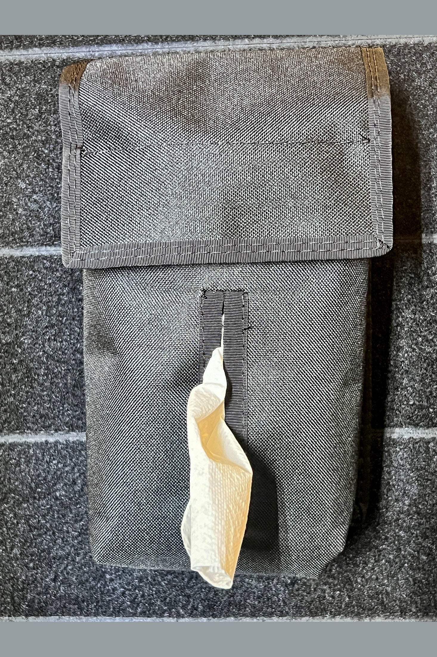 Modular Velcro Kleenex tissue pocket attached to fabric surface with a tissue partially pulled out