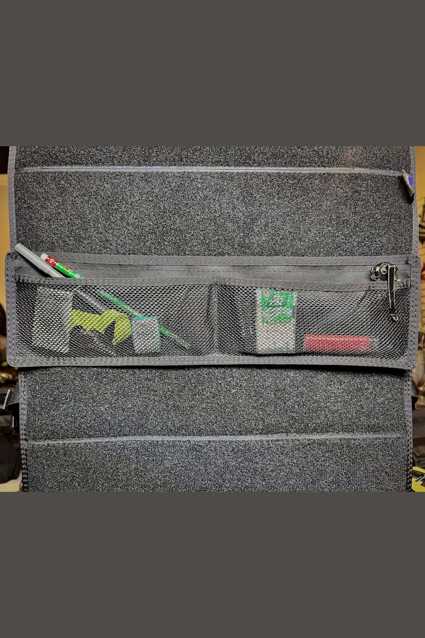 Small mesh Modular Velcro Pocket attached to carpeted surface holding small items