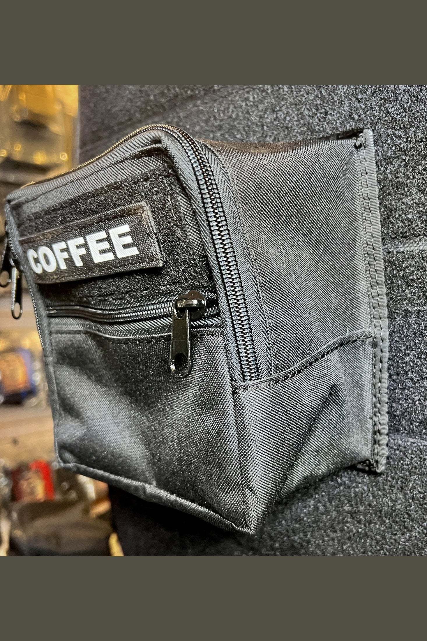 Black Mini Cargo Modular Velcro pocket attached to carpeted wall with "COFFEE" label and zipper compartment