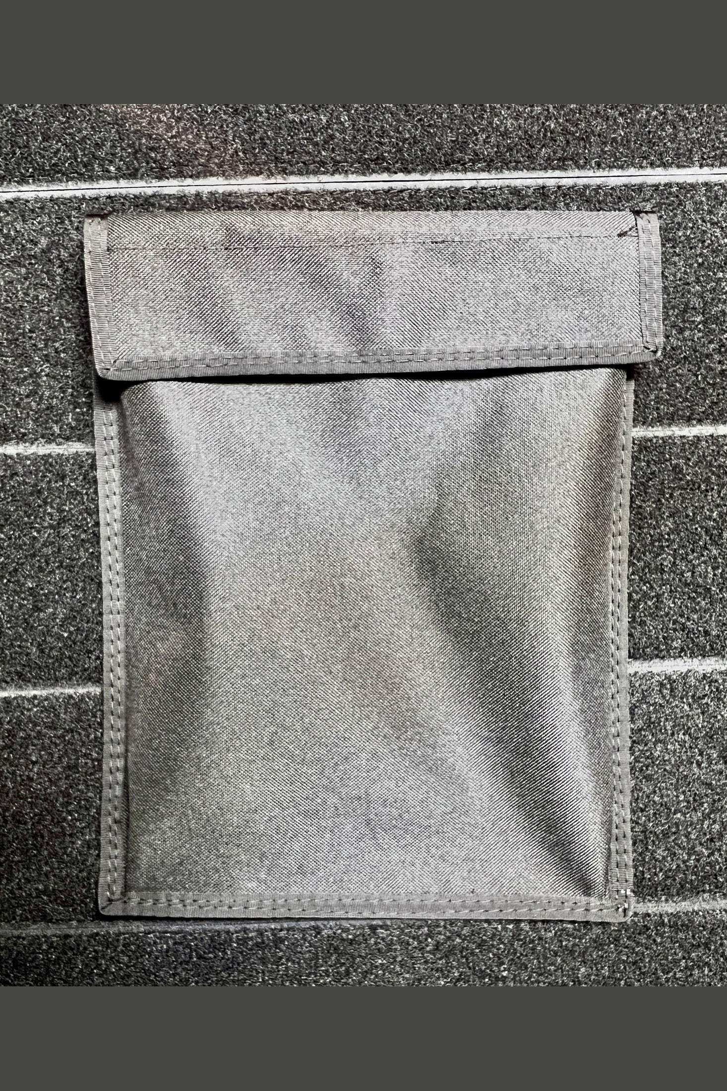 Modular Velcro 8.5" x 11" flat pocket attached to carpeted surface for versatile storage