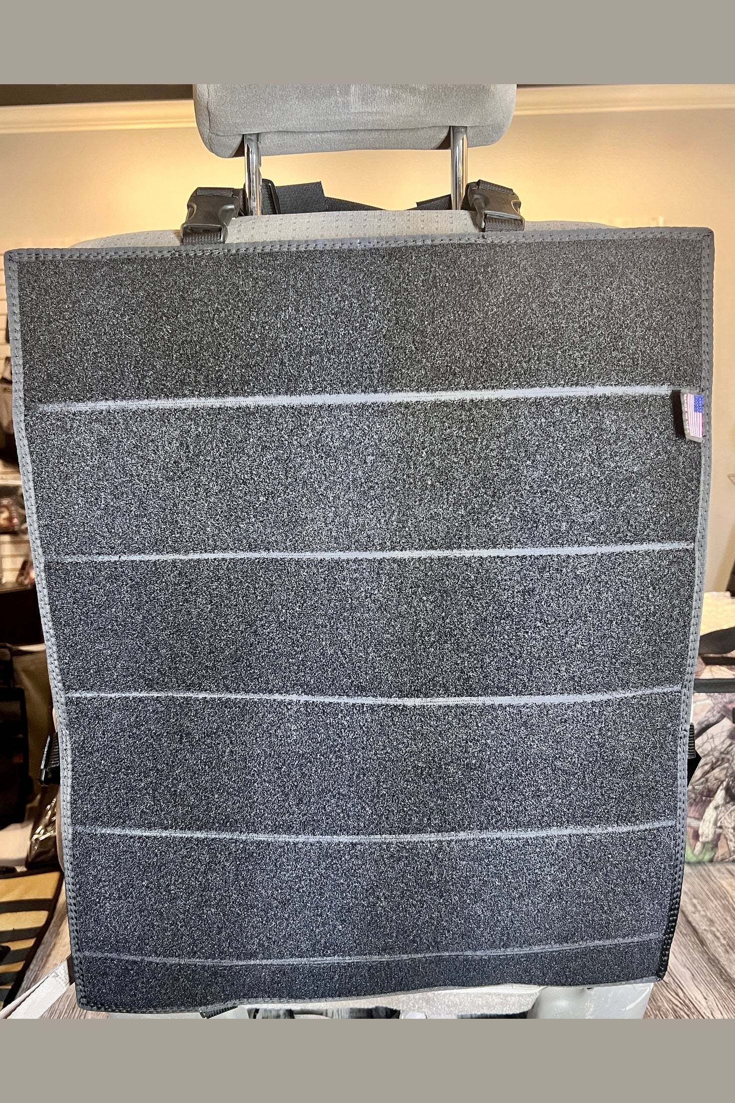 Modular Velcro seat organizer with multiple attachment strips hanging on a car seat back for customizable vehicle storage