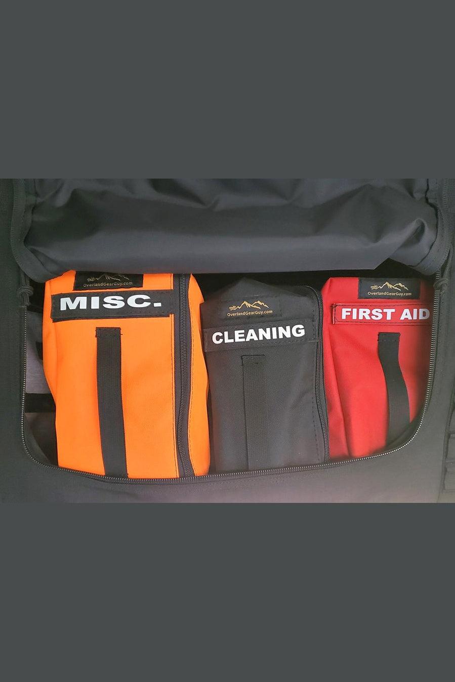 Van overhead storage locker divider bags labeled MISC, CLEANING, and FIRST AID for organized van storage