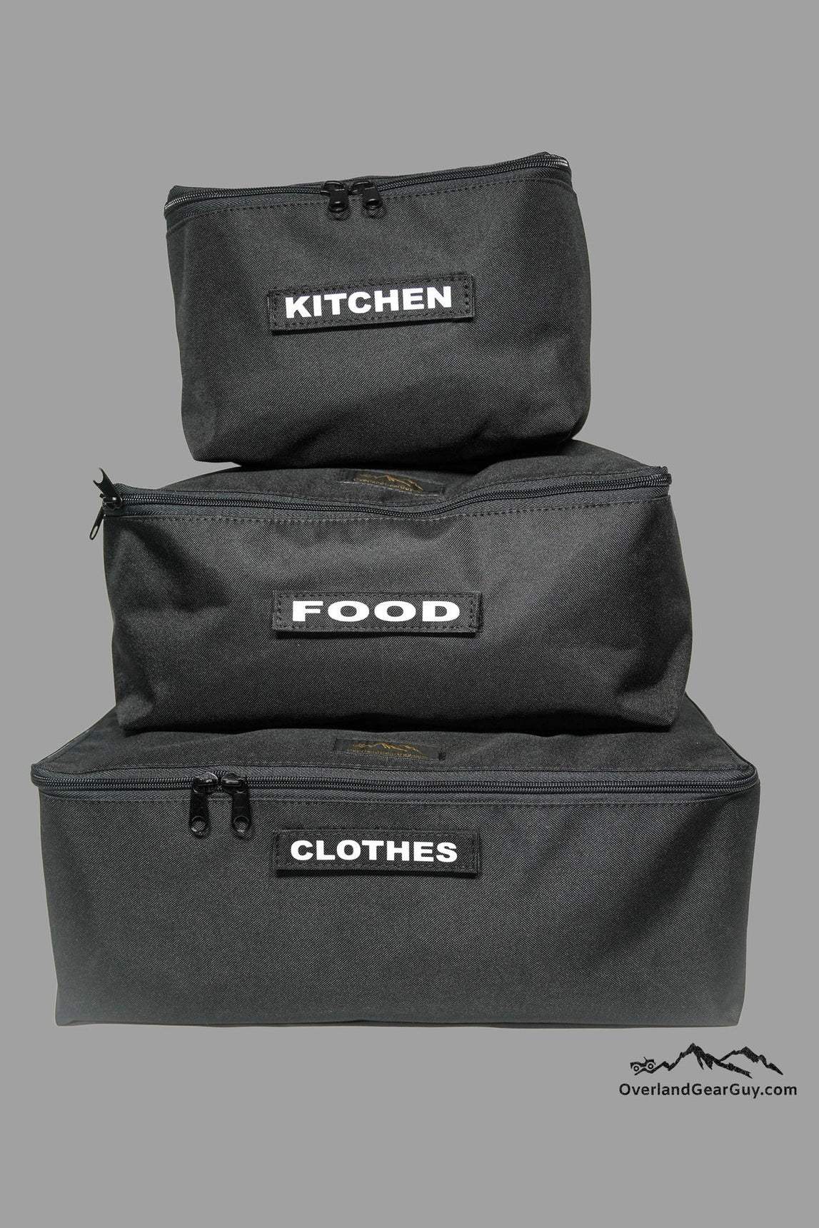 Stacked black Overland Gear Guy Storage Cubes labeled kitchen, food, and clothes for organized gear storage