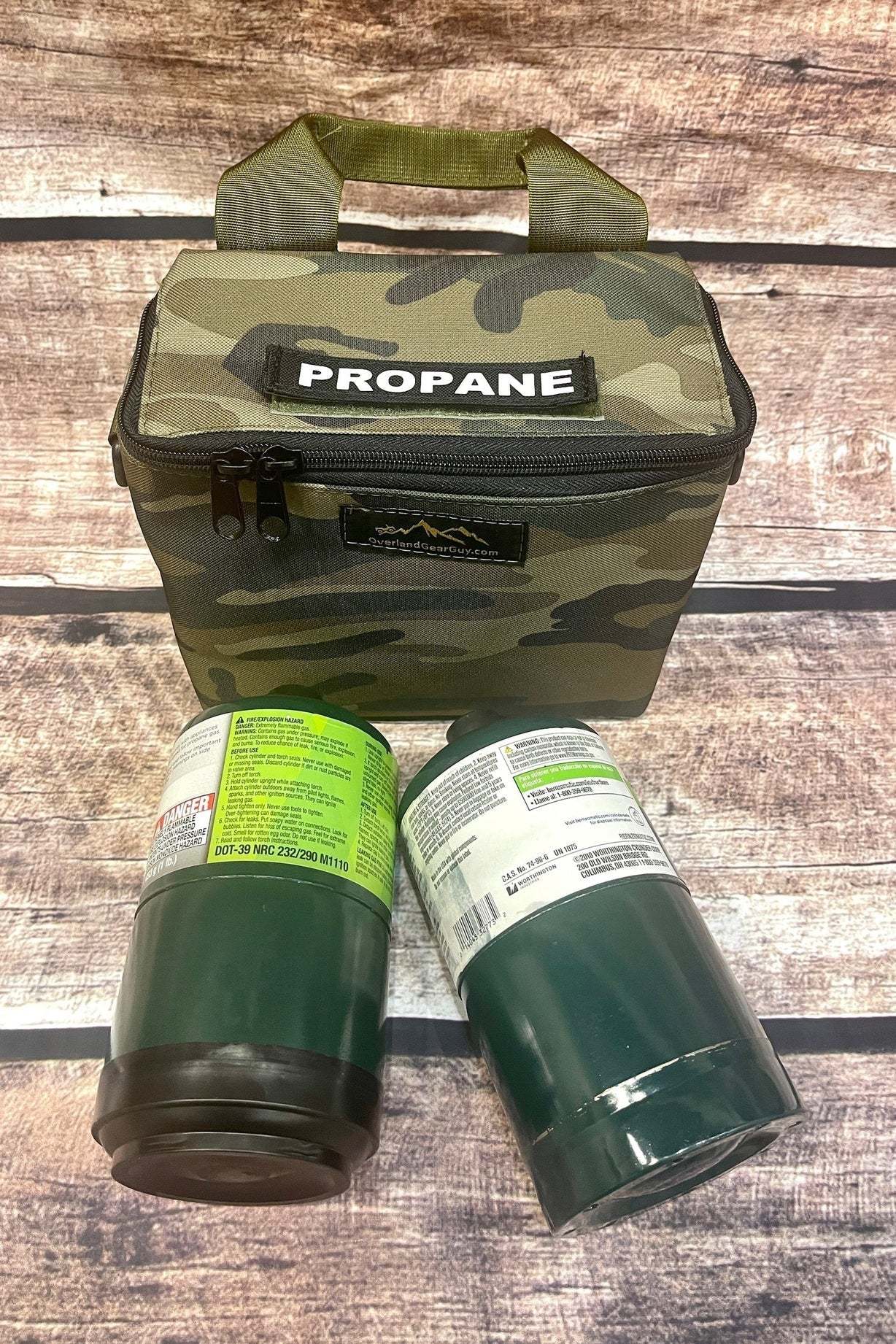 Camouflage dual propane bottle pouch with two green propane bottles on wooden surface