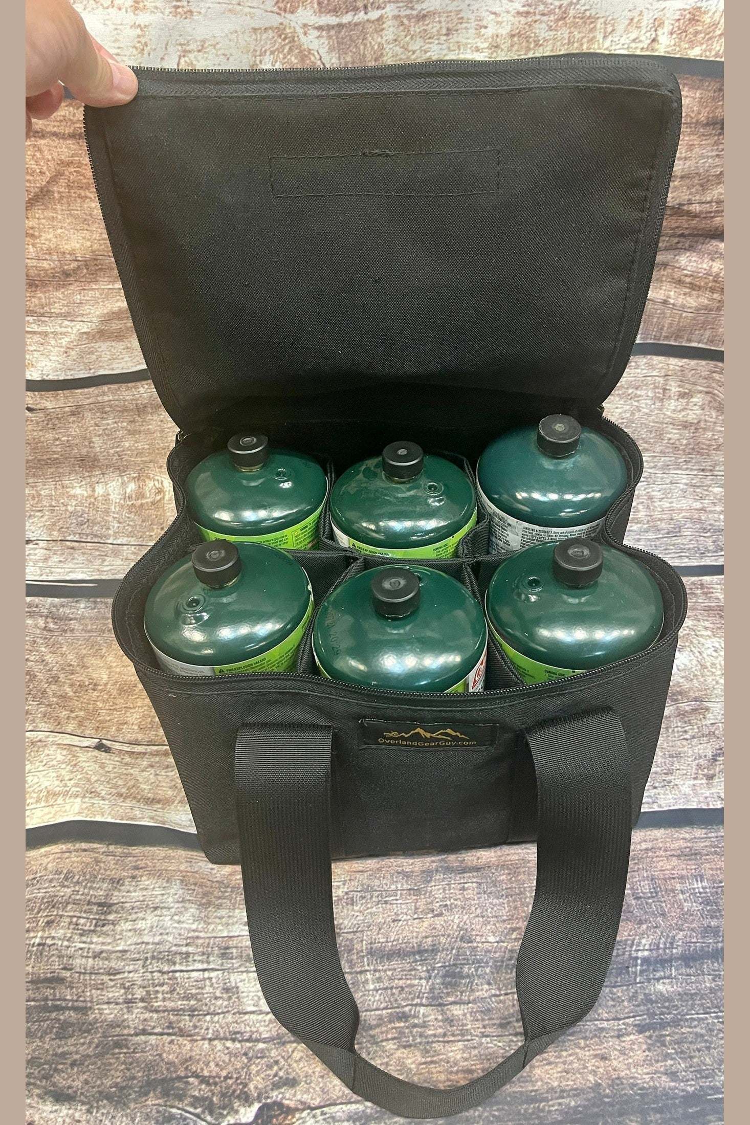 Black propane bottle bag carrying six 1-pound green propane bottles with top flap open for easy access