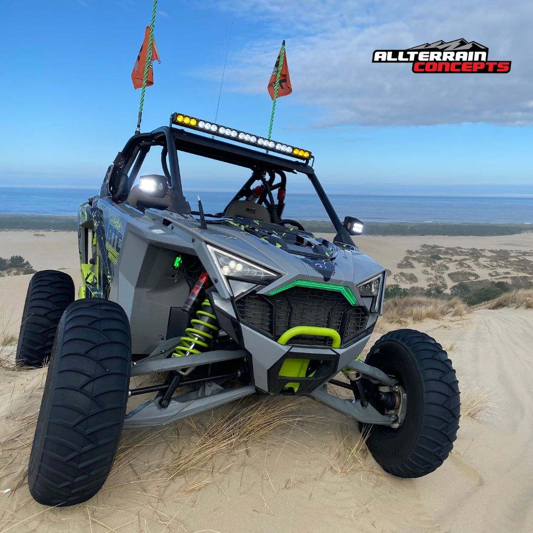 Polaris RZR Pro R off-road dune buggy with LED light bar and all-terrain tires on sandy trail