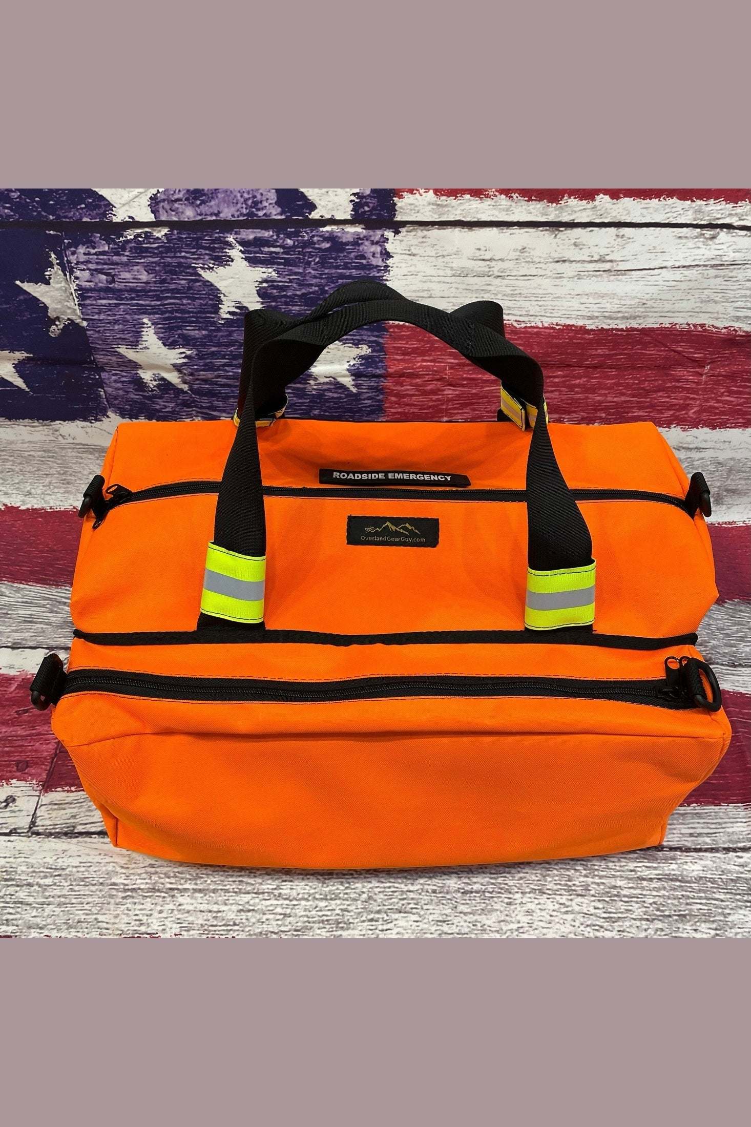 Orange roadside emergency bag with reflective handle tags and multiple compartments for organized storage of essential car safety gear