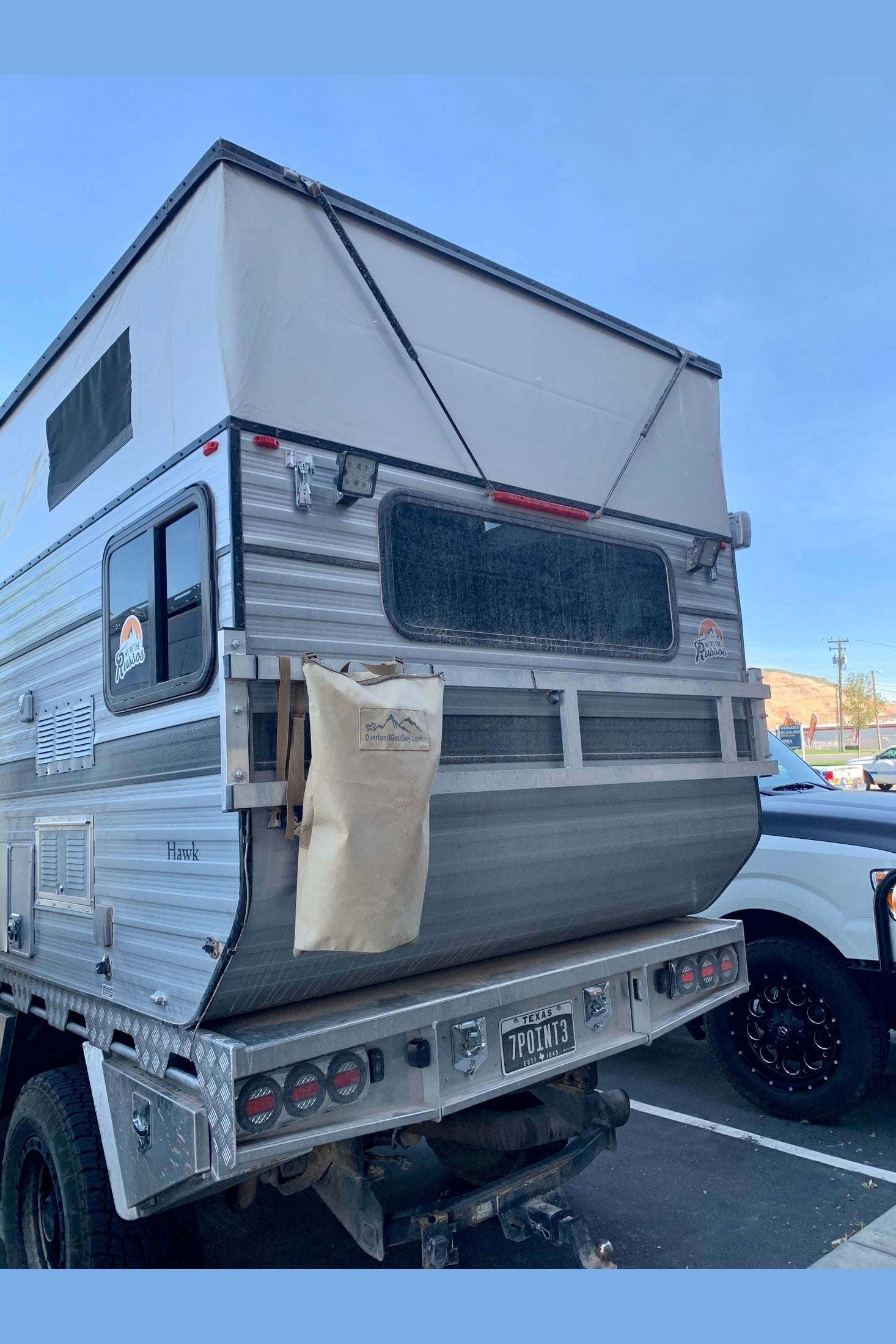 Pack It Out Bag attached to camper truck for outdoor trash and recycling storage