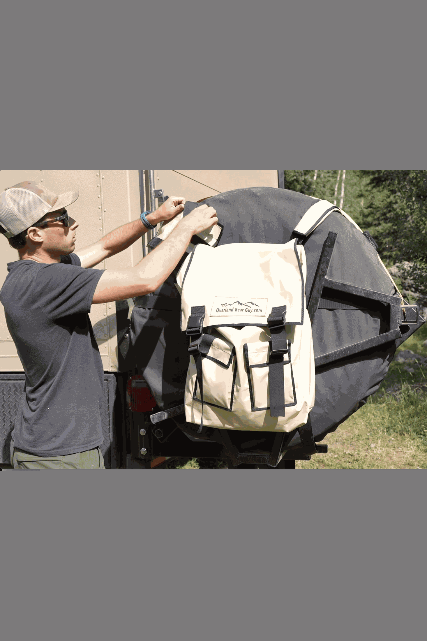 Man securing spare tire trash bag on vehicle with strap covers in outdoor setting