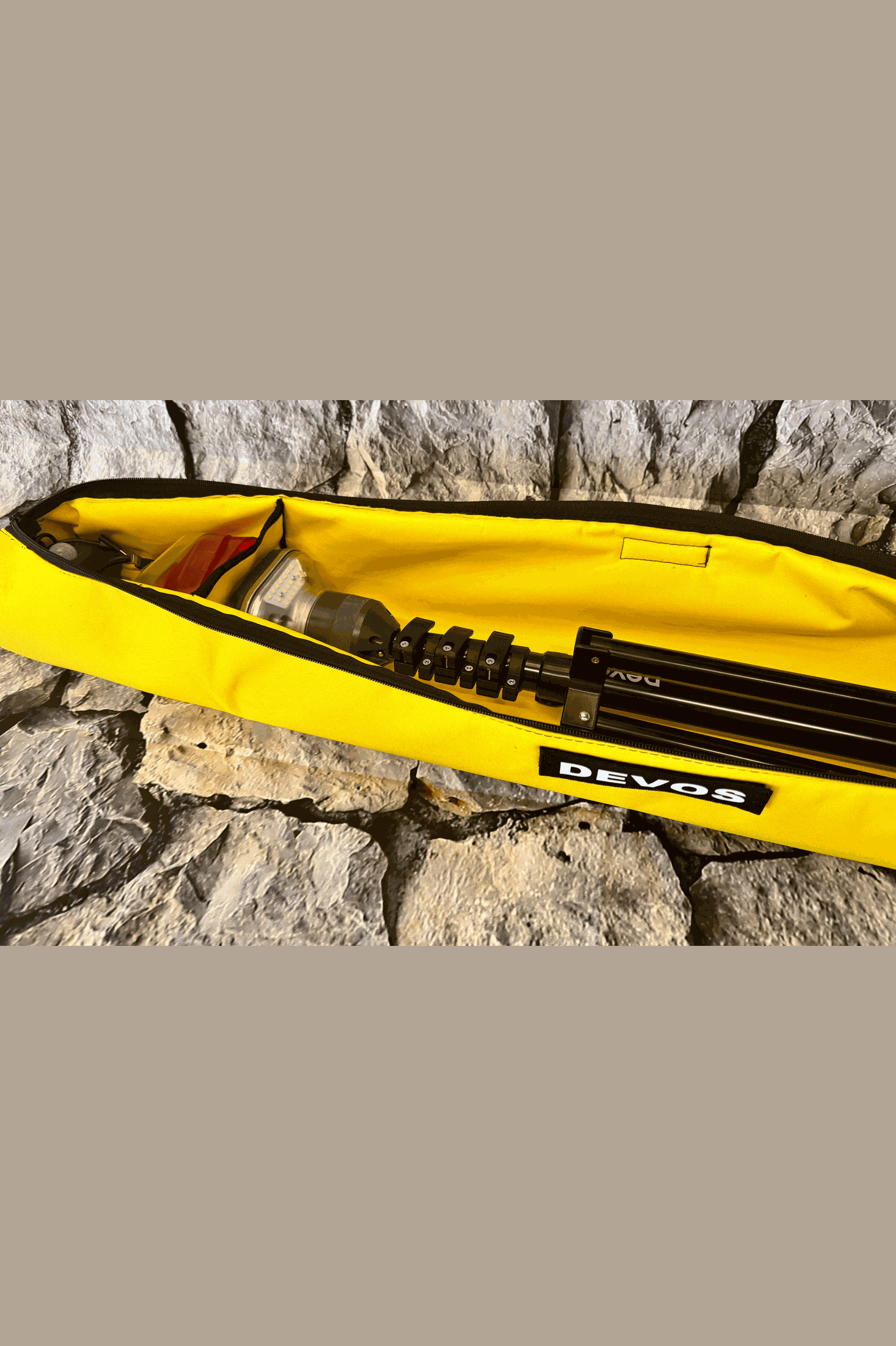 Yellow Devos II Light Stand Carry Bag with folded LightRanger lantern and stand inside on stone surface