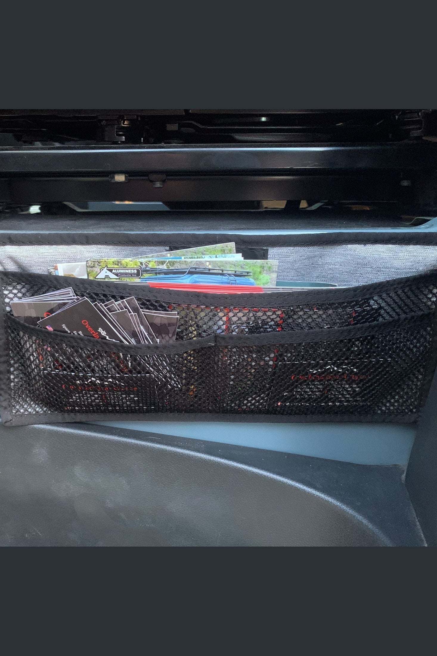 Magnetic seat base organizer pouch attached to car seat base for storing maps and documents