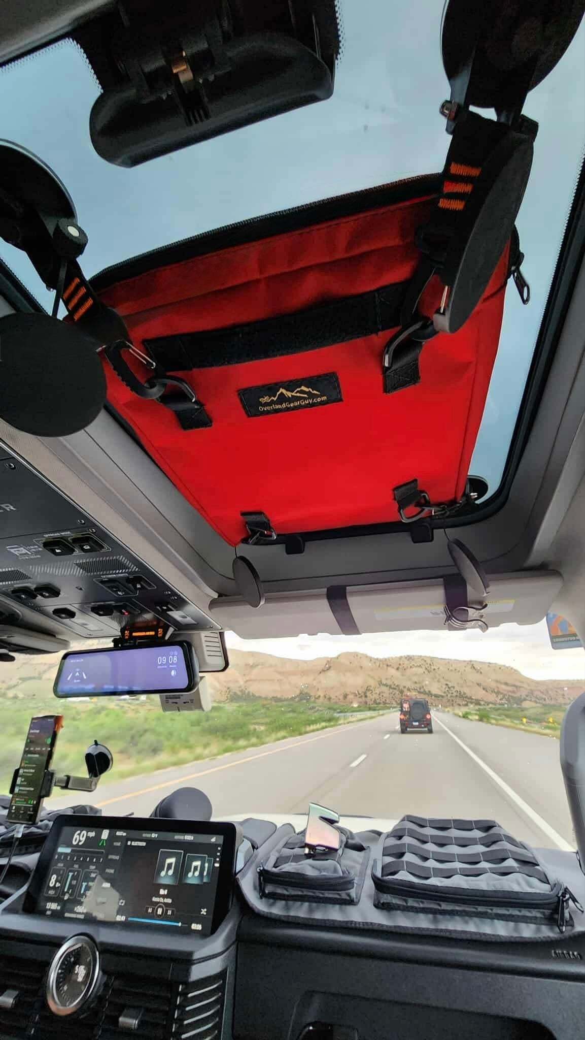 Red Starlink Safari Mount Bag attached to INEOS Grenadier sunroof with secure straps for outdoor use