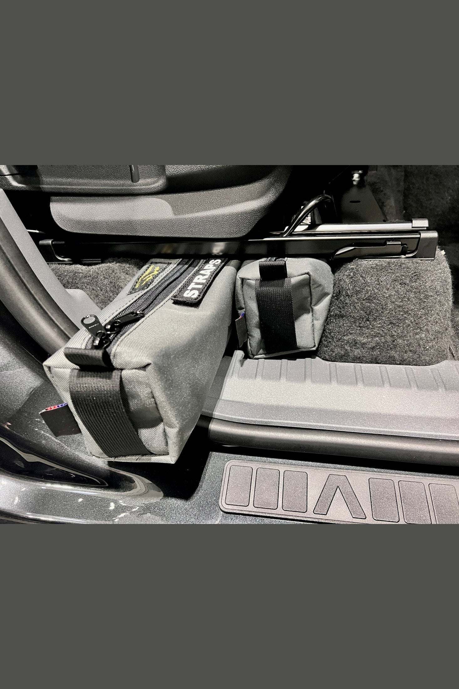 INEOS Grenadier Under Seat Storage Bags installed under car seats for organized storage