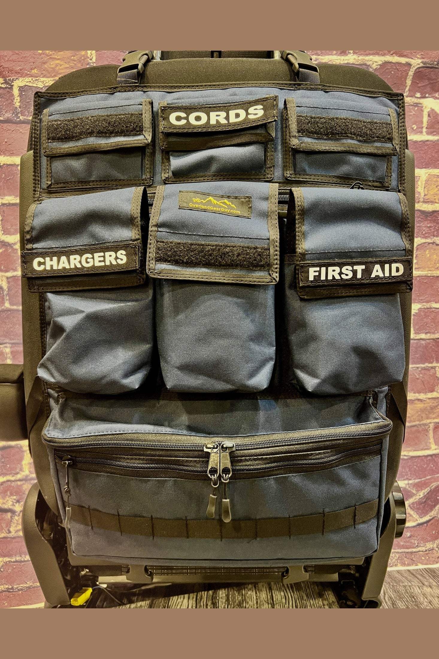 Universal Seat Organizer with multiple labeled pockets for cords, chargers, and first aid, durable and easy to install on car seats