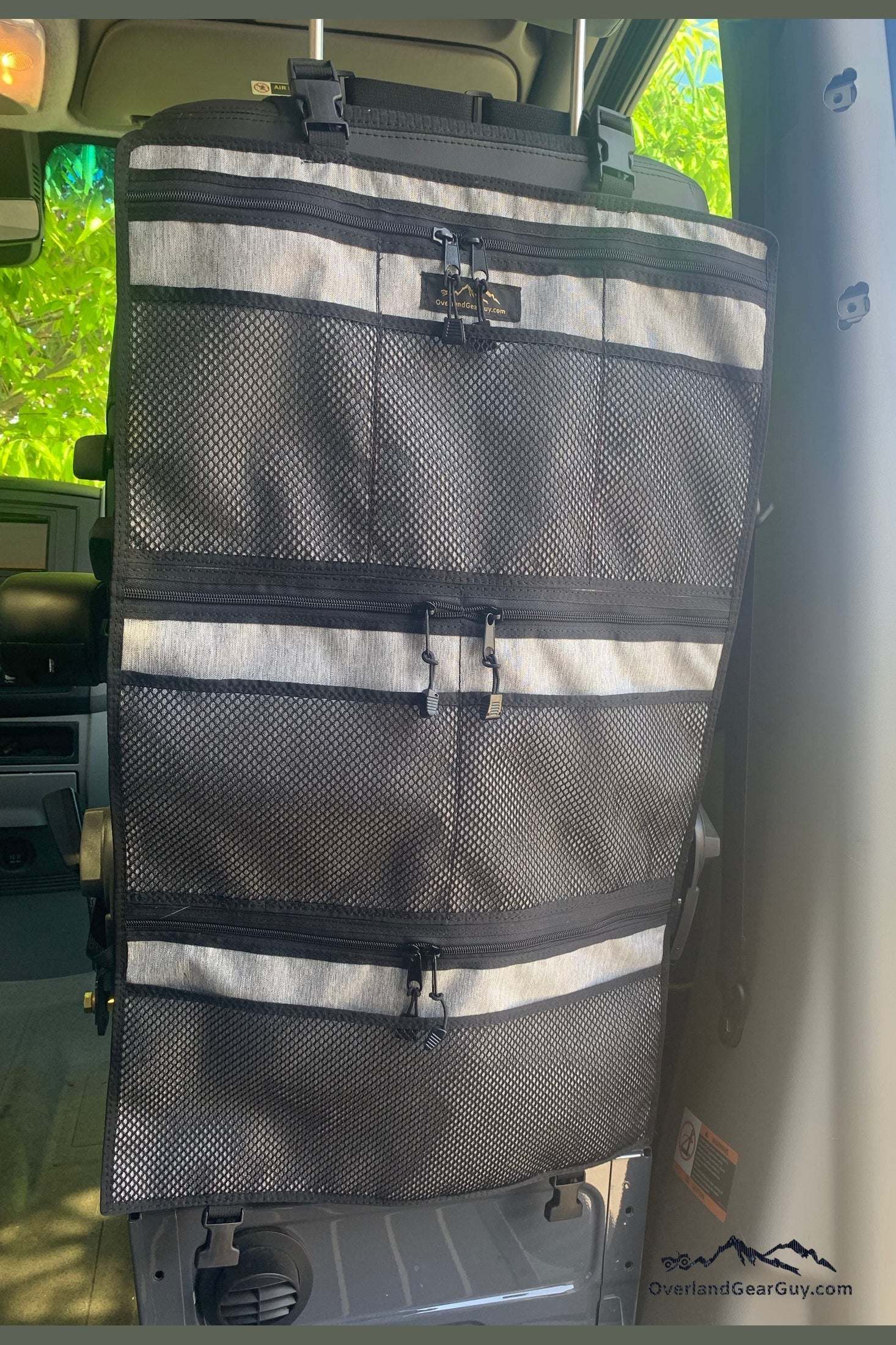 Yosemite Seat Organizer hanging on a high back vehicle seat with multiple mesh and zippered pockets for storage