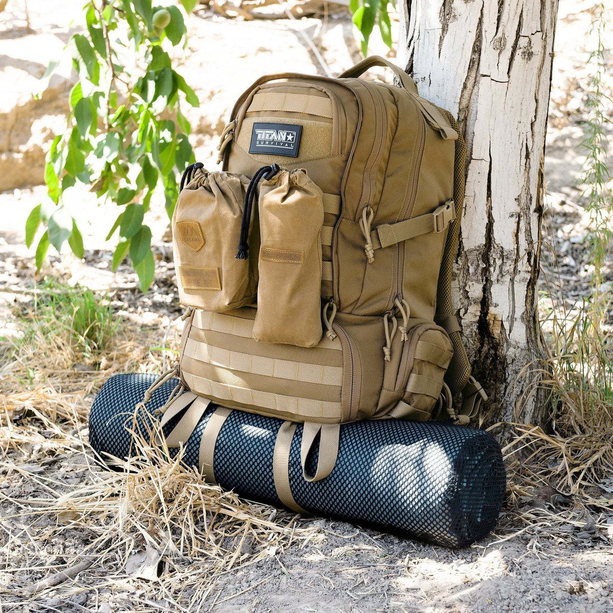 50L tactical backpack with MOLLE system and hydration gear under a tree in the outdoors.