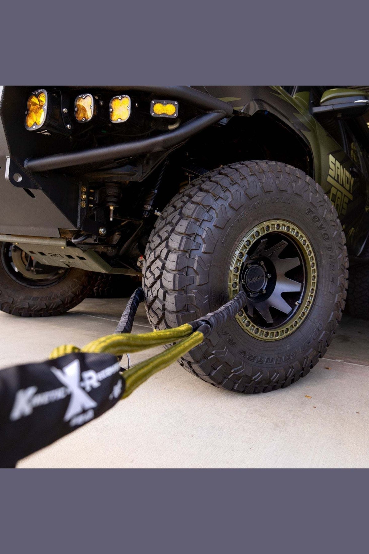 Hero Bridle in use, connected to off-road vehicle wheel for recovery.