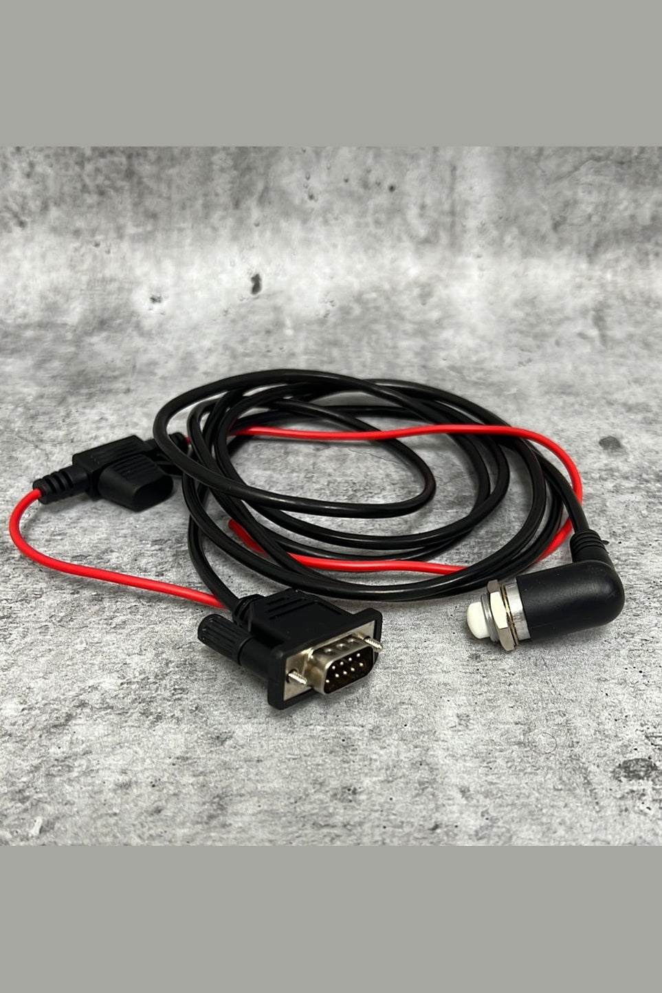 SatComm PTT with connectors and cables on concrete background.
