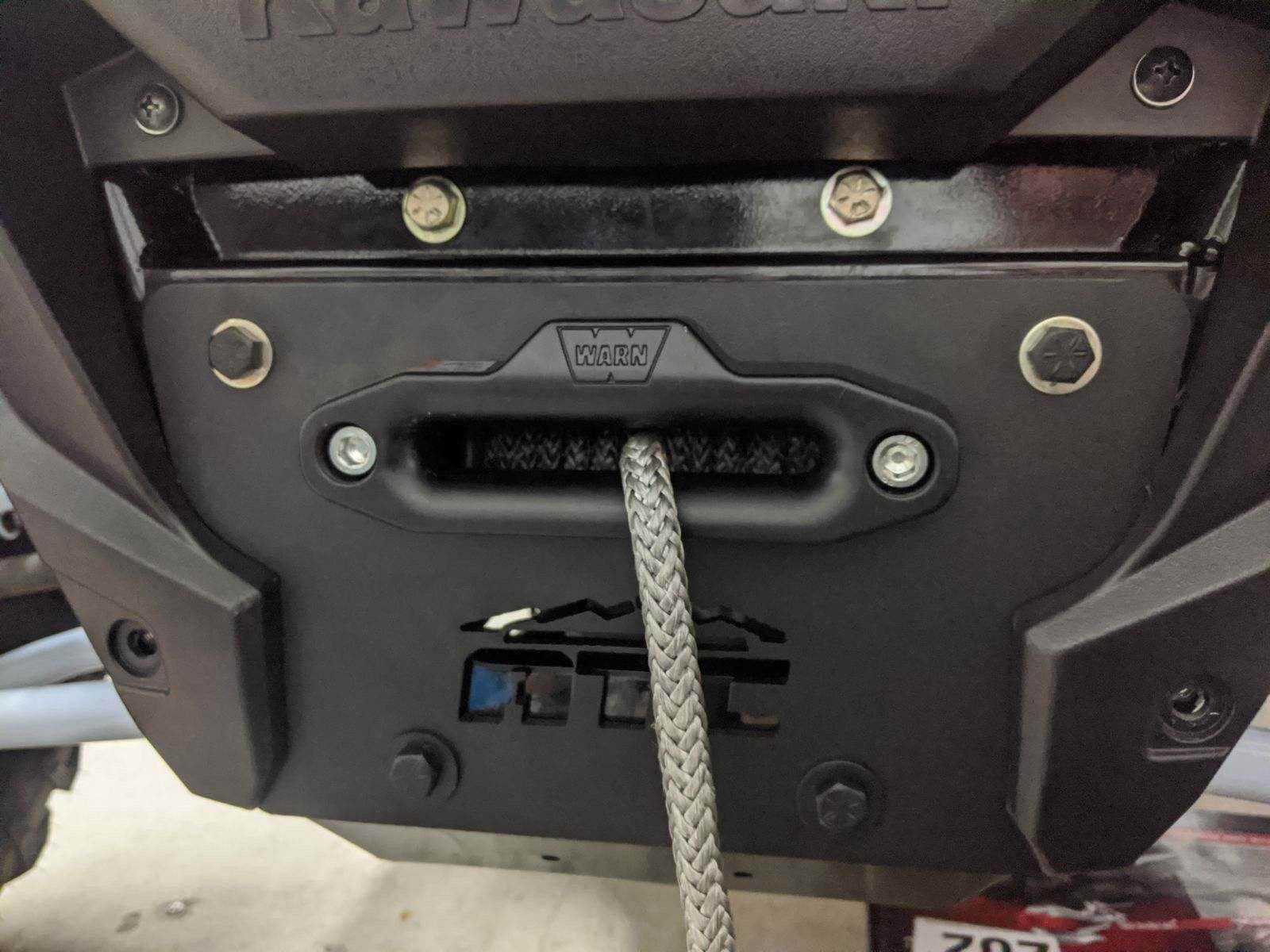 KRX Winch Plate with black powder coat and grade 8 hardware mounted on front of KRX 1000.