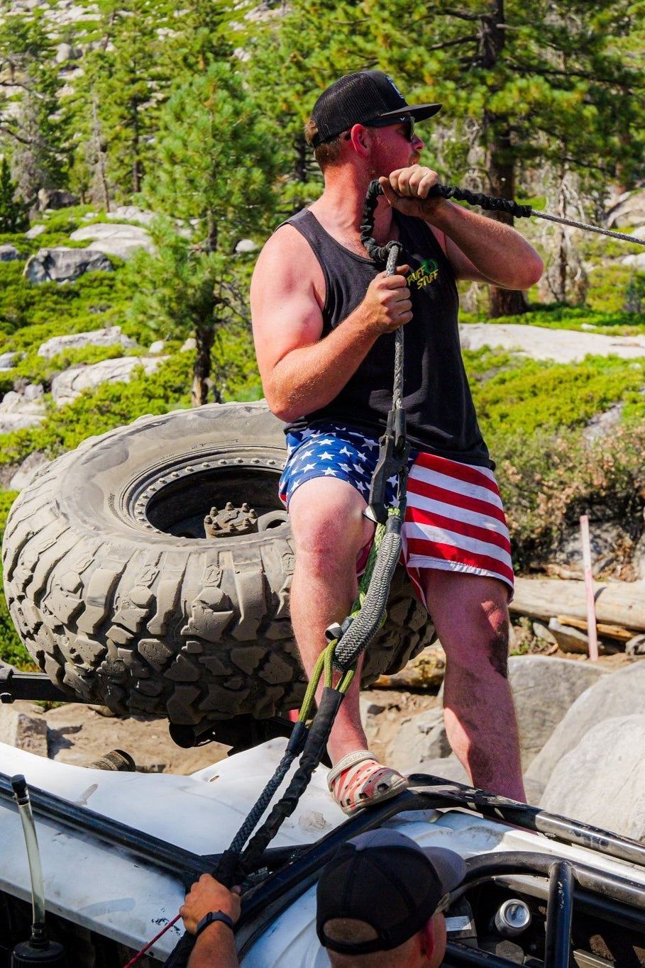 Man using Titan Recovery Kit for vehicle recovery in rugged terrain.
