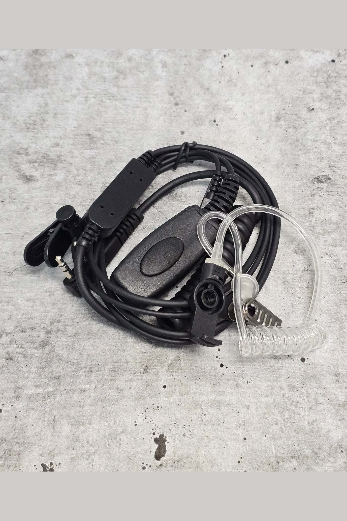 Clearance security headset with coiled earpiece and microphone on concrete background