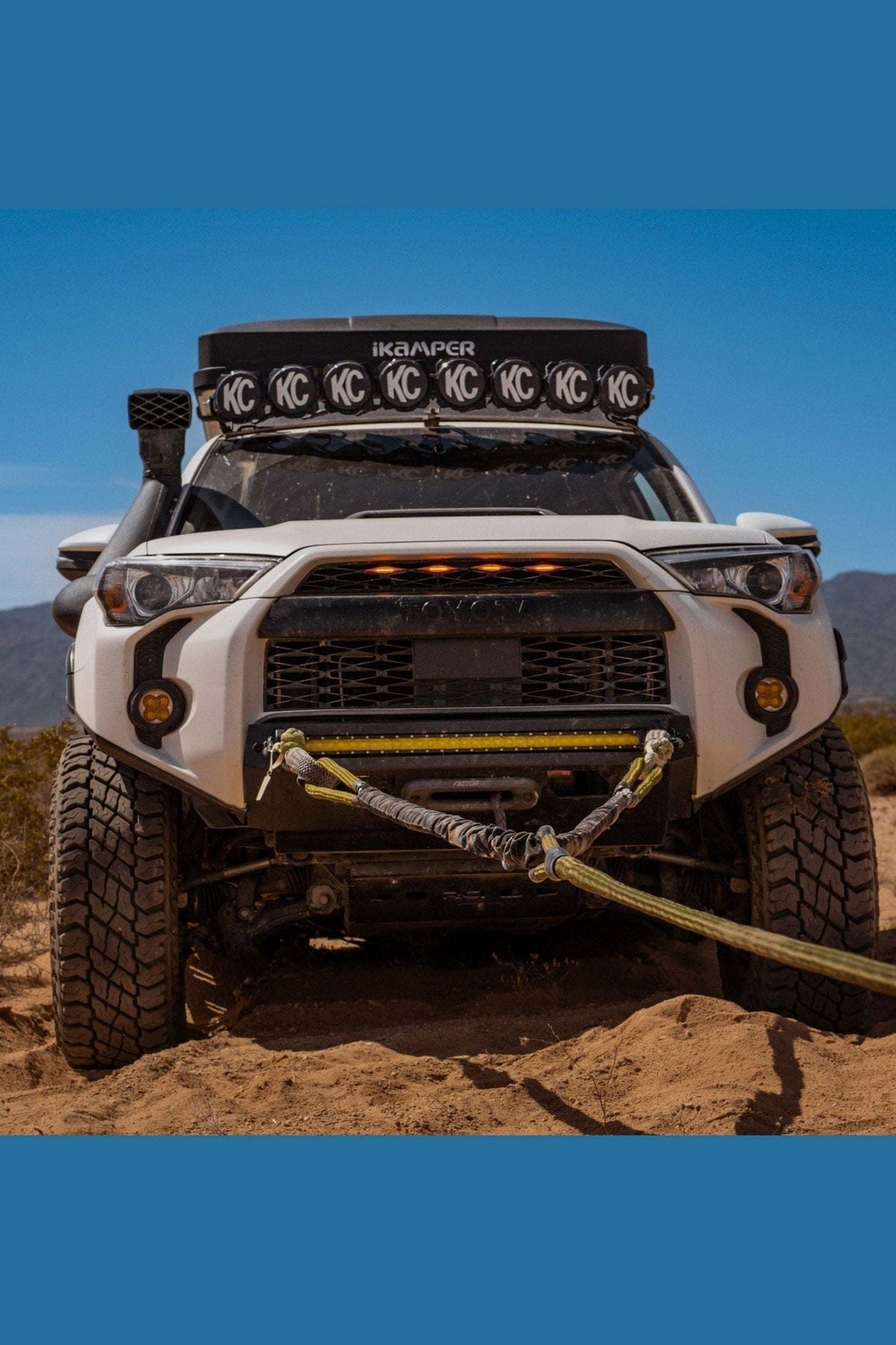 Off-road vehicle using Titan Recovery Kit on sandy terrain.