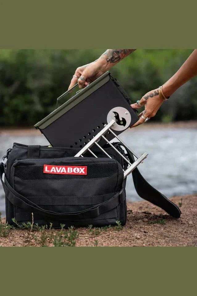 Emergency Bugout Bag with LavaBox grill at a riverside setting.