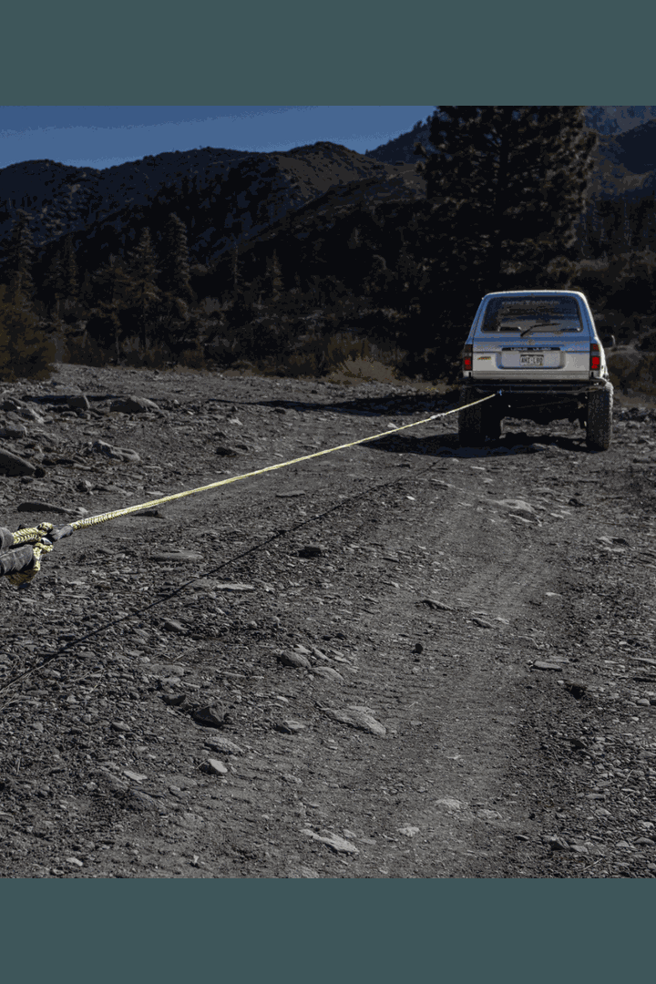 50' synthetic winch line extension securing a vehicle on a rugged, rocky trail.