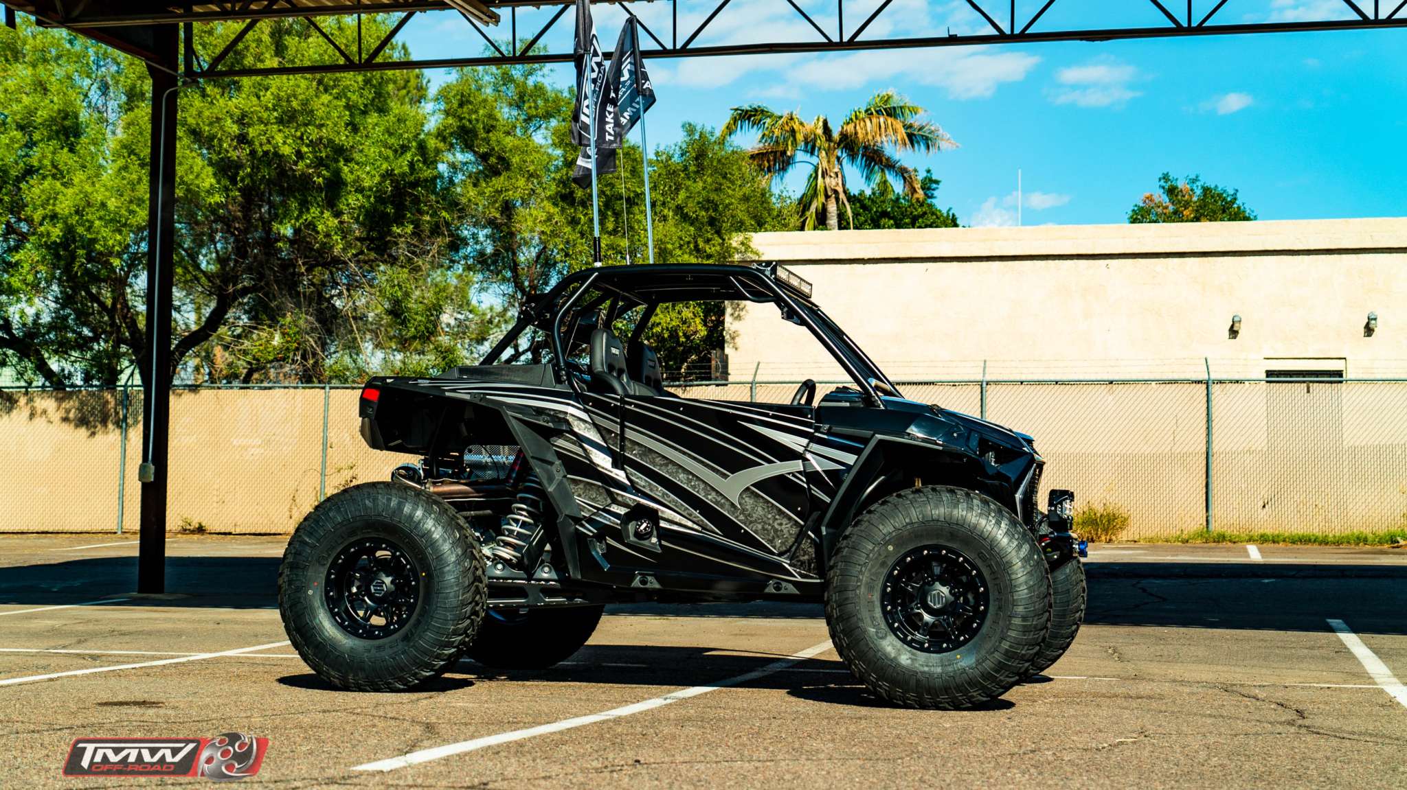 Black Polaris RZR XP 1000 with TMW 2 Seat RZR Doors installed in parking lot under clear sky